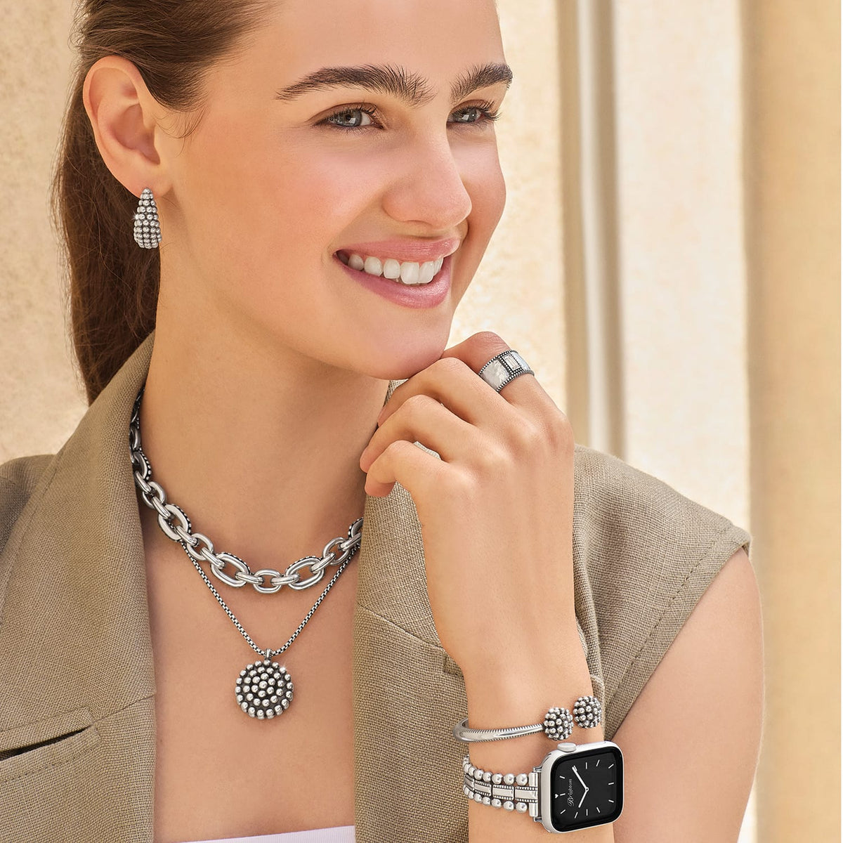 Model wearing Brighton silver-plated beaded hoop earrings with coordinating Brighton chain necklace, pendant, ring, bracelet, and watch